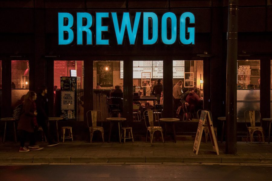 A BrewDog bar lit up at night