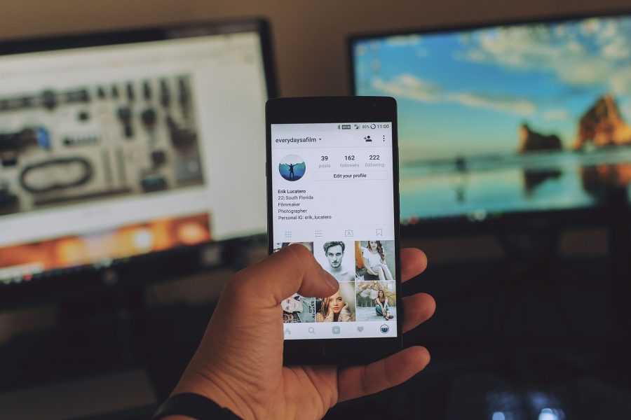 A content creator checks an Instagram profile at an editing desk