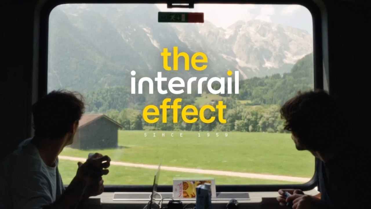 A traveller looks out of a train window at the Alps in Interrail's The Interrail Effect film