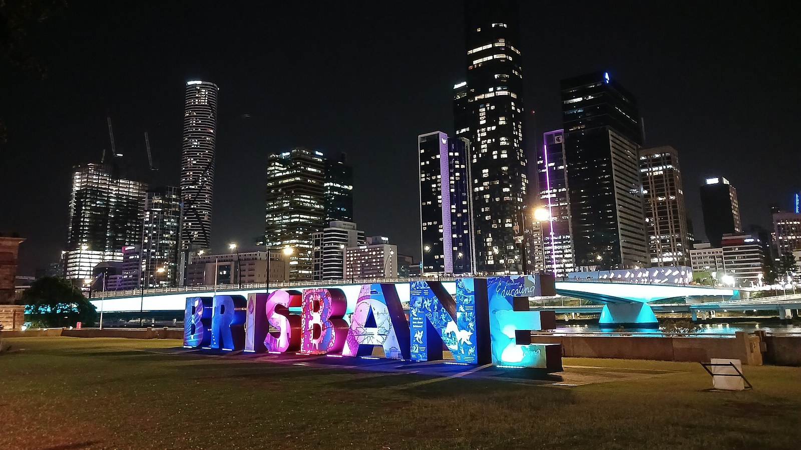 The illuminated Brisbane sign on the South Bank with the city skyline behind